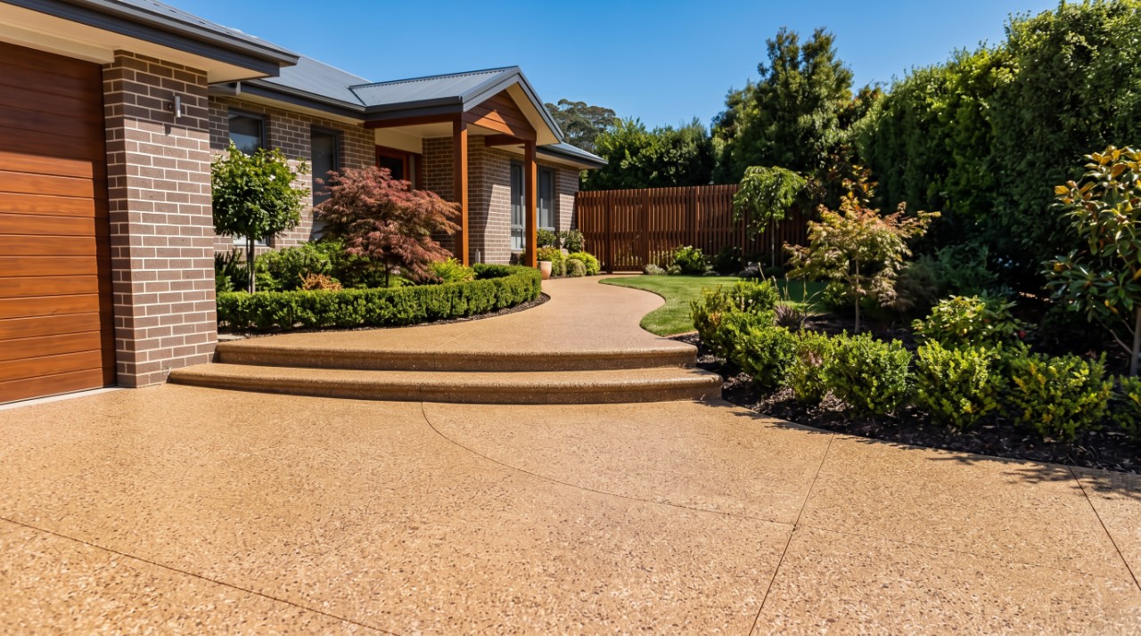 Honey exposed aggregate driveway curving into a matching path and wide bullnosed steps at a Launceston home