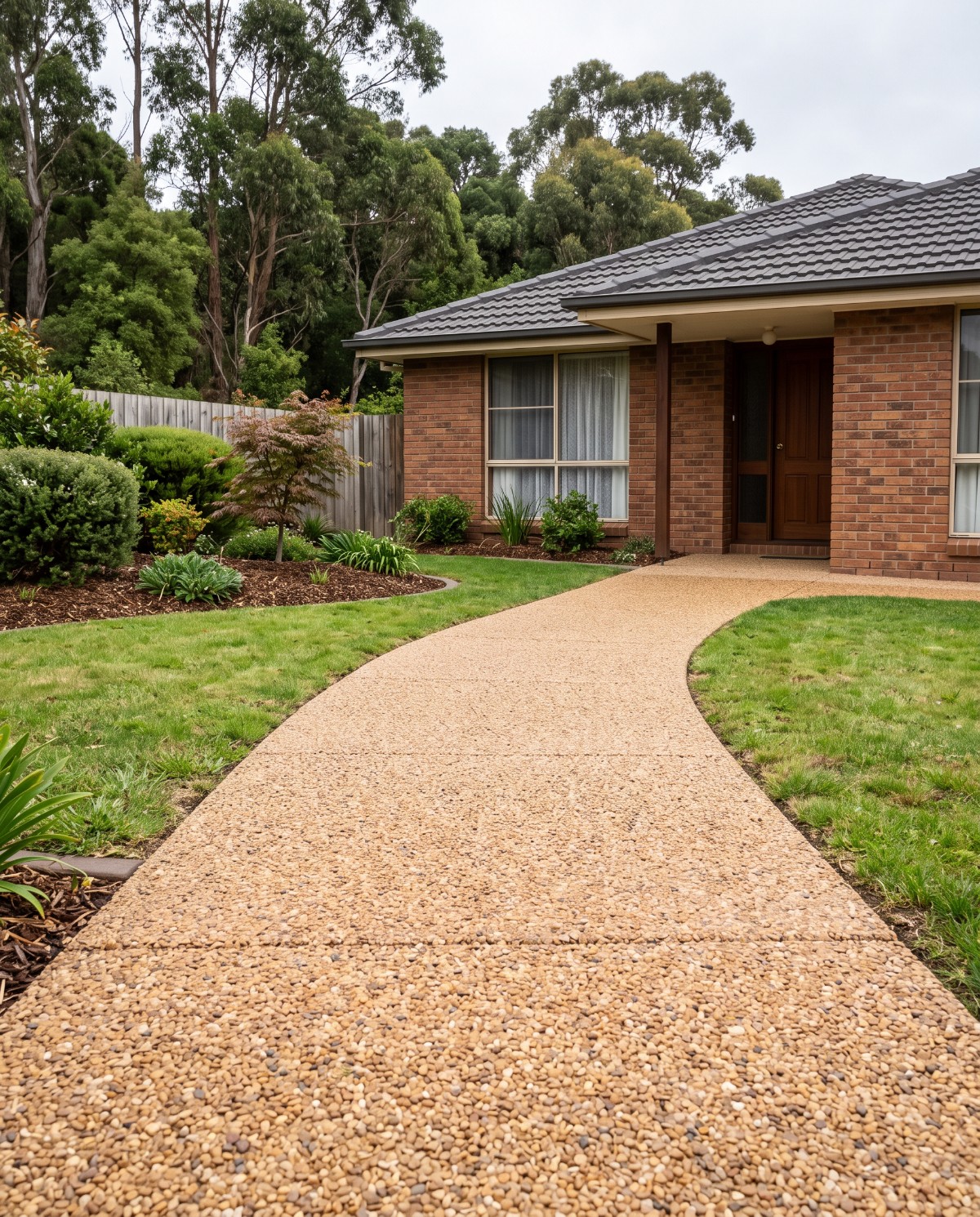 Exposed aggregate front path curving to the entry of a Launceston home